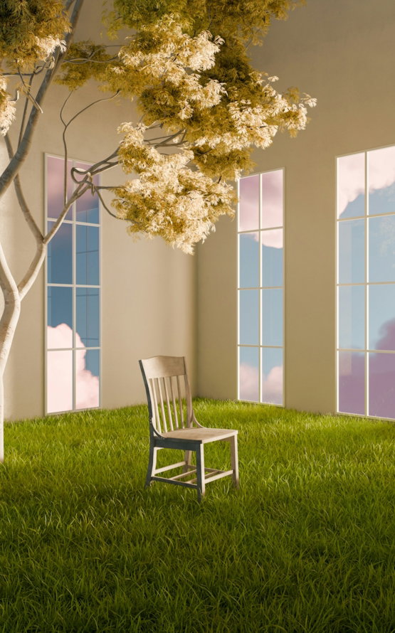 White chair on green grass, tree, and windows with sky.